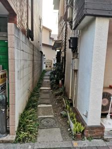 an alleyway between two buildings with plants at grori house in Musashino