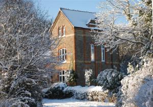 a brick building in the snow with snow covered trees at Shooting Box Tower in Battle