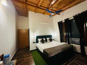 a bedroom with a bed and a ceiling fan at Heaven by lake & woods in Bhīm Tāl