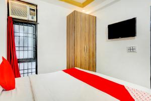 a bedroom with a bed and a tv and a window at OYO Royal Hotel in Ghaziabad