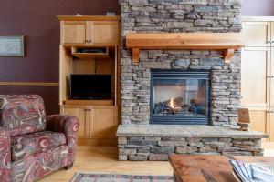 sala de estar con chimenea de piedra y chimenea en Eagle Ridge Pet-Friendly Chalet, en Big White
