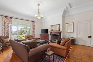 a living room with a couch and chairs and a fireplace at Clydesville in Queenscliff