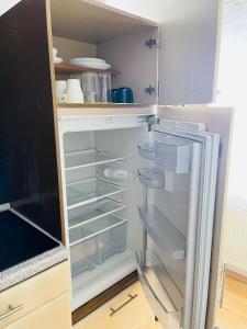 um frigorífico vazio com a porta aberta numa cozinha em Barbarosa Rüsselsheim Königstädten 1 em Königstädten