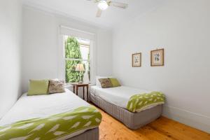 two beds in a room with white walls and a window at Clydesville in Queenscliff