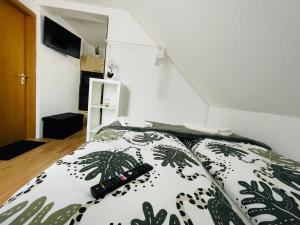 um quarto com dois controlos remotos numa cama em Barbarosa Rüsselsheim Königstädten 1 em Königstädten