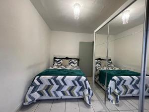 a bedroom with two beds and a mirror at Apartamento familiar com estacionamento in Porto Alegre