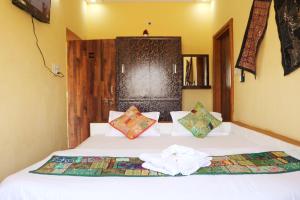 Un dormitorio con una cama blanca con toallas. en Urmila Homestay en Jaisalmer