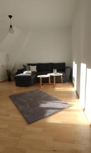 City Leaves Apartments في Sankt Aegyd am Neuwalde: غرفة معيشة مع أريكة وطاولة