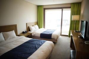 a hotel room with two beds and a television at Hotel Master Daecheon in Boryeong