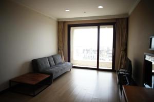 a living room with a couch and a large window at Hotel Master Daecheon in Boryeong