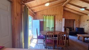 eine Küche und ein Esszimmer mit einem Tisch und Stühlen in der Unterkunft Cabañas Cerro Colorado Lago Colbún in Talca