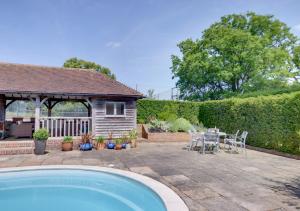 um quintal com uma piscina, uma mesa e cadeiras em Middle Barn em Leigh
