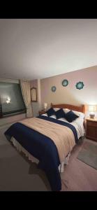 1 dormitorio con 1 cama grande con almohadas azules en Departamento San Alfonso del Mar, primer piso, en Algarrobo