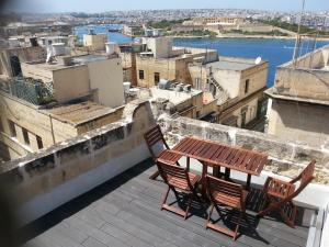 a table and chairs on a balcony with a view of a city at Valletta Maisonette Malta in Valletta