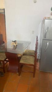 cocina con mesa, sillas y nevera en Cabaña 6 personas zonas verdes., en Los Santos