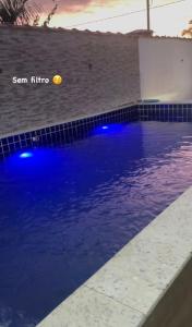 een zwembad met blauwe verlichting in een huis bij Espaço praia boraceia in Bertioga