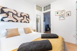 a white bedroom with a large white bed with a large at Plaza De la Iglesia in Rincón de la Victoria