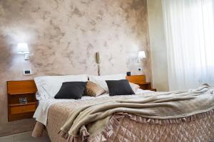 Hotel Marconi في فيوجي: غرفة نوم بسرير كبير عليها بطانية