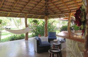 eine Veranda mit einer Hängematte und Stühlen unter einem Pavillon in der Unterkunft Casa El Rancho 1 in Estero