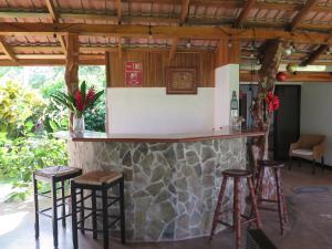 eine Bar mit Hockern in einem Zimmer mit einer Steinmauer in der Unterkunft Casa El Rancho 1 in Estero
