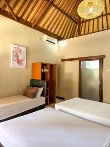 a bedroom with two beds and a chandelier at Trawangan Oasis in Gili Trawangan