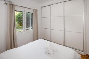 ein Schlafzimmer mit einem weißen Bett und Handtüchern darauf in der Unterkunft Newly Remodeled Dream Condominiun in Kifisia with Garden & Grass Lawn in Athen