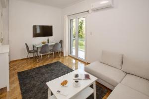 - un salon avec un canapé et une table dans l'établissement Newly Remodeled Dream Condominiun in Kifisia with Garden & Grass Lawn, à Athènes