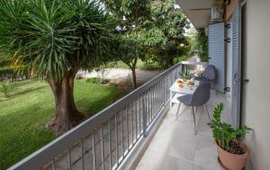 einen Balkon mit einem Tisch und einem Baum in der Unterkunft Newly Remodeled Dream Condominiun in Kifisia with Garden & Grass Lawn in Athen