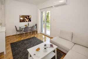 een woonkamer met een bank en een tafel bij Newly Remodeled Dream Condominiun in Kifisia with Garden & Grass Lawn in Athene