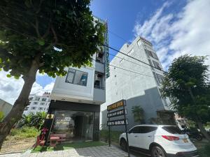 a white car parked in front of a building at OYO 1224 Motel Phuong Linh in Danang