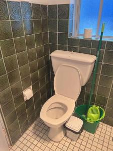 a bathroom with a toilet and a green tiled wall at Ocean View 1 bedroom Private Apartment Near Maroubra Beach in Sydney