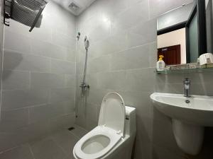 a white bathroom with a toilet and a sink at OYO 1224 Motel Phuong Linh in Danang