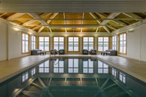 una piscina cubierta en una habitación grande con ventanas y techo en Rodd Miramichi en Miramichi