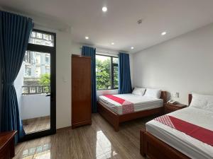 1 dormitorio con 2 camas y ventana en OYO 1224 Motel Phuong Linh en Da Nang