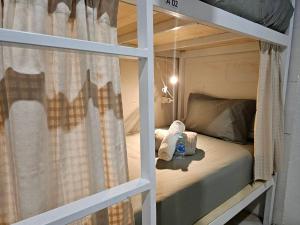 Etagenbett mit Fenster in einem Zimmer in der Unterkunft Hao Norn Hostel in Thongsala