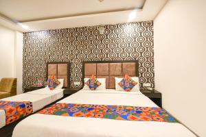 - une chambre avec 2 lits et un mur à motifs dans l'établissement FabHotel Belwood, à New Delhi