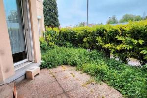 una ventana exterior de un edificio con arbustos y césped en Appartement Cosy proche Paris en Le Bourget