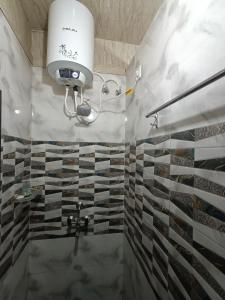 バラナシにあるKashi Vandanam Homestayのタイル張りの壁のバスルーム(シャワー付)