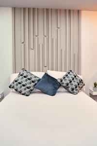 a white bed with two pillows on top of it at Departamento Marloma #1 in Ensenada
