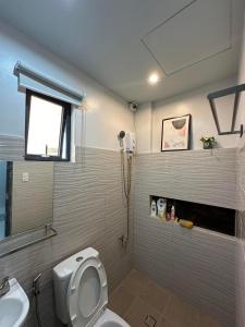 a bathroom with a toilet and a sink at Grey Oasis Staycation 1 Bedroom in Manila