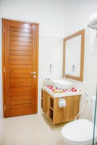 a bathroom with a sink and a toilet and a mirror at Shanta Villa in Sanur