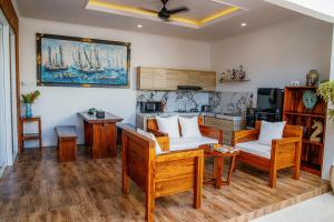 una sala de estar con muebles de madera y una pintura en la pared en Shanta Villa en Sanur