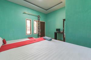 een groot bed in een kamer met groene muren bij RedDoorz near Pantai Ujung Genteng in Cijaringao