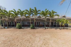 a house with palm trees in front of it at RedDoorz near Pantai Ujung Genteng in Cijaringao