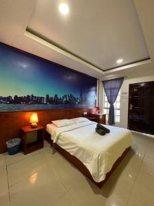a bedroom with a large bed with a view of a city at Landcons Hotel & Resort in Pantai Cenang