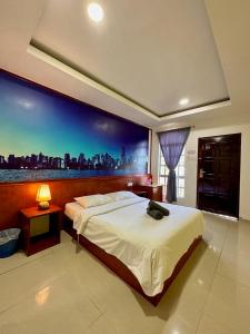 a bedroom with a large bed with a large painting on the wall at Landcons Hotel & Resort in Pantai Cenang