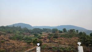 a view of a hill with mountains in the background at Coastal Paradise in Alibaug