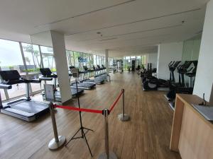 ein Fitnessstudio mit vielen Laufbändern und Maschinen in der Unterkunft Luxurious Flat 2BR in Gold Coast PIK Penjaringan in Jakarta