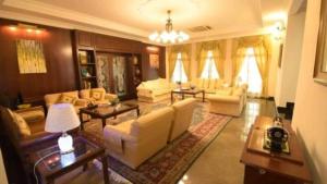 un grand salon avec des canapés et des tables dans l'établissement CASA ANDALUSIA, à Alor Setar