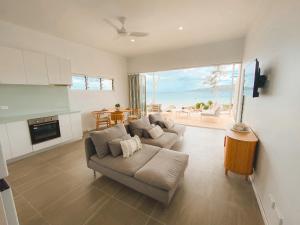 een woonkamer met een bank en uitzicht op de oceaan bij M Resort & Spa in Port Vila